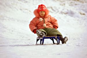 Child sledding in the snow.